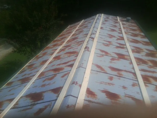 Rusted metal roof panels with new wood purlins before replacement — Storm Damage Roof Repair in Eagle Bay by Roofing Brothers