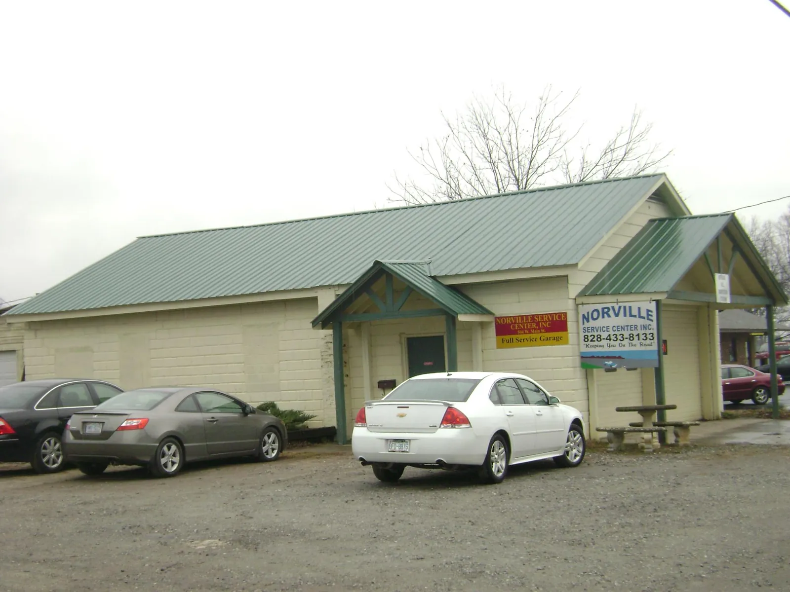 Green metal roof on a service garage with a covered entry in Eagle Bay