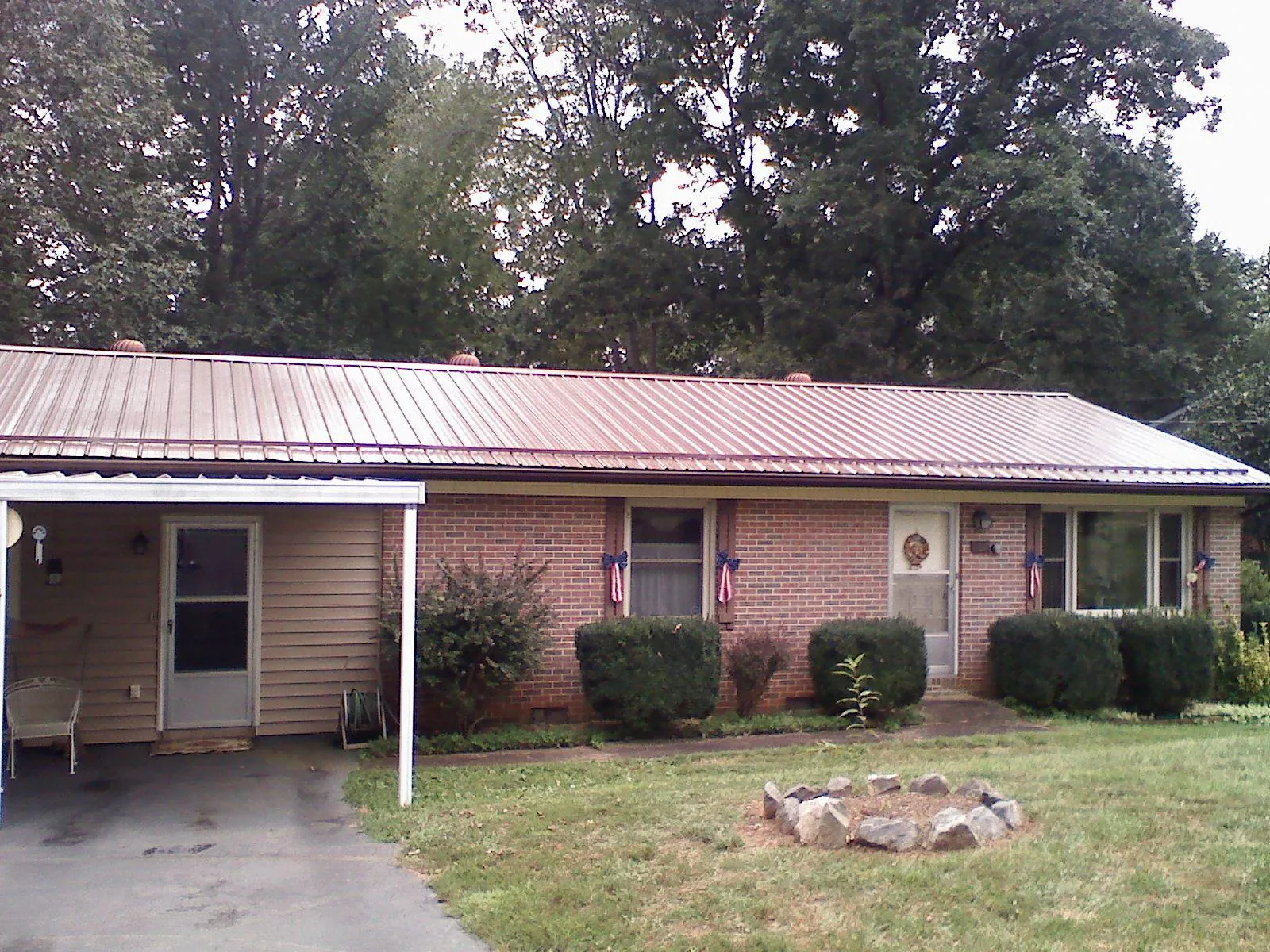 Bronze metal roof and carport on a brick ranch home — Roof Repair work by our crew in Eagle Bay